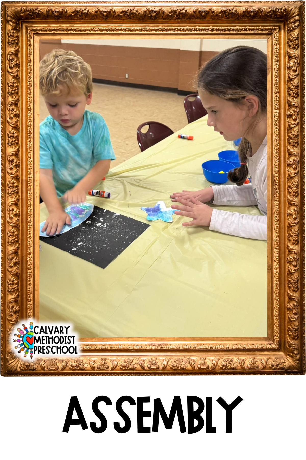 Image of a young girl helping a young boy to glue a planet cut out onto a starry background
